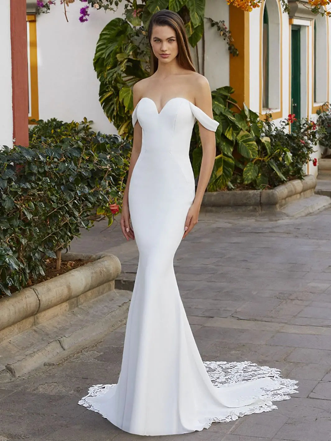 The Robe Nala offers a flattering mermaid silhouette with an off shoulder sweetheart neckline, designed with intricate lace details on a corset bodice. Perfect for brides looking for a versatile and stylish wedding dress.