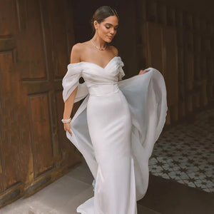 Elevate your special day with our Robe Josy. This stunning satin wedding dress features a sexy backless design and a flattering mermaid silhouette, perfect for highlighting your figure. The off-the-shoulder neckline adds a touch of allure to this gorgeous piece. Walk down the aisle in style with our beautiful and slimming Robe Josy.
