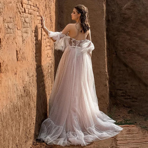 Indulge in the exquisite elegance of our Bohemian A Line Wedding Dress - Dress Violet. The beautiful off shoulder design and the fluffy sleeves will make you feel like a romantic goddess, while the elegant lace applique and backless style add a touch of sensuality. Say "I do" in style with this eye-catching dress that will make you feel confident and stunning on your special day.