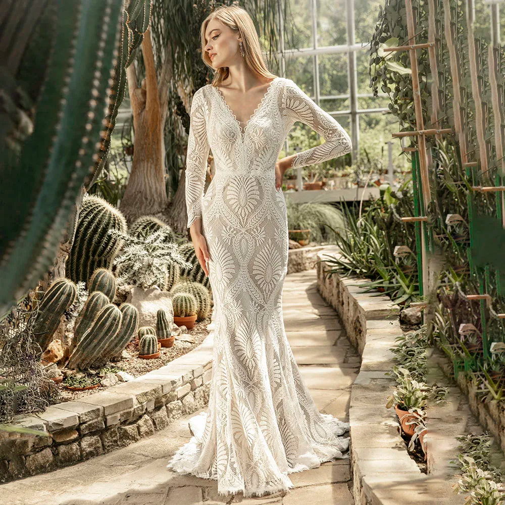 Unleash your inner bohemian goddess in our elegant Robe Mauva. The mermaid cut and lace detailing accentuate your curves, while the cutout V neck adds a touch of allure. Perfect for a rustic beach wedding, this dress is customizable for the perfect bodycon fit. The long sleeves and brush train buttons complete this luxurious bridal look.