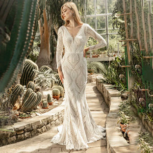 Unleash your inner bohemian goddess in our elegant Robe Mauva. The mermaid cut and lace detailing accentuate your curves, while the cutout V neck adds a touch of allure. Perfect for a rustic beach wedding, this dress is customizable for the perfect bodycon fit. The long sleeves and brush train buttons complete this luxurious bridal look.