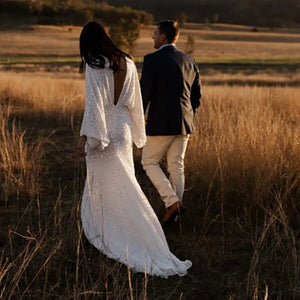 Robe Severine is an exquisite wedding dress tailored to perfection. Richly detailed with lustrious sequined V-neck and long batwing sleeves, it is tailored for an unforgettable bridal gown experience. Its custom-made overweight sizing ensures a comfortable fit and its crystals add a graceful touch to this elegant gown.