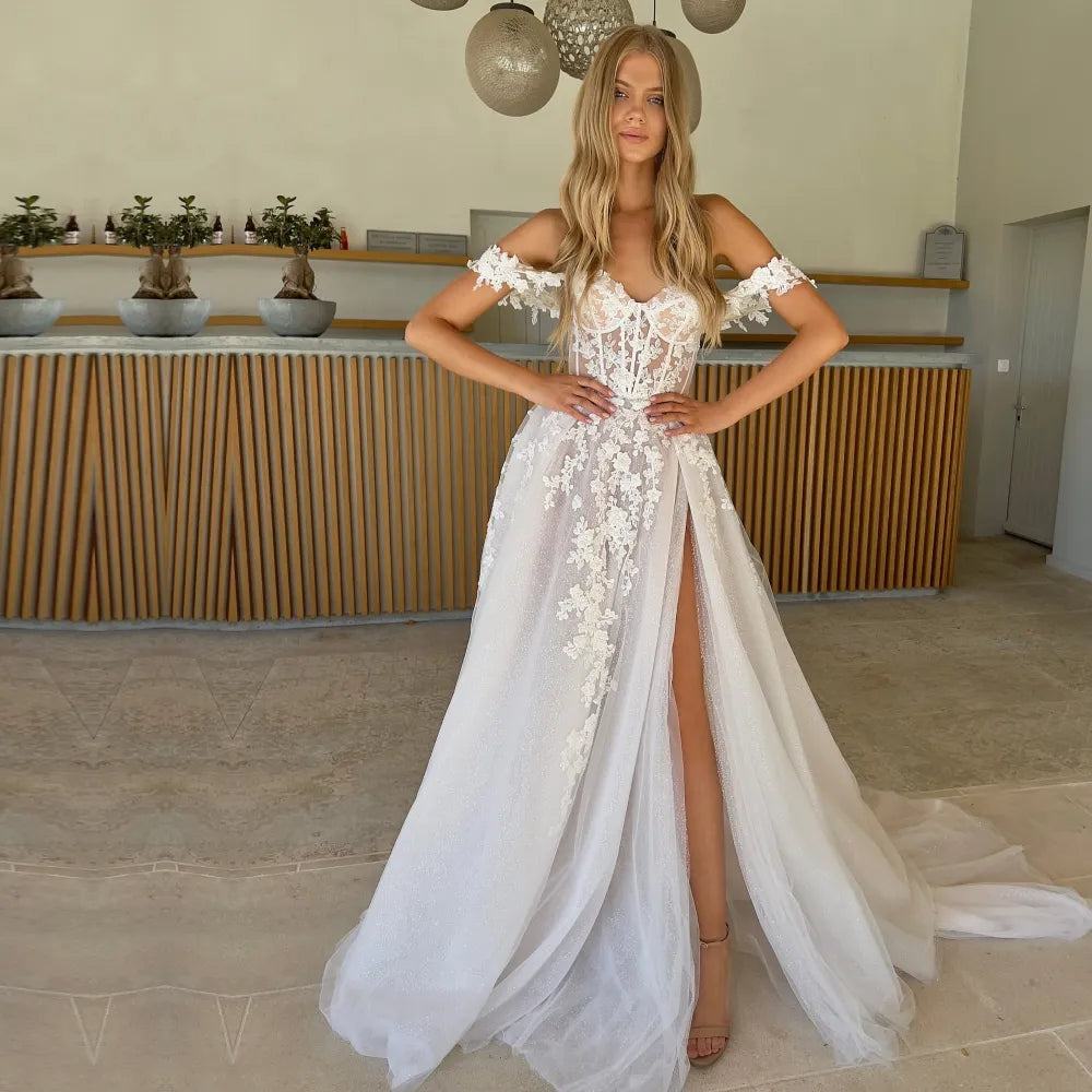 Make a statement on your special day in the Nadine! This off-the-shoulder bridal gown features a sweetheart neckline and a voluminous A-line skirt with a daring side slit for added drama. Look breathtakingly beautiful as you walk down the aisle in this custom-fit showstopper!