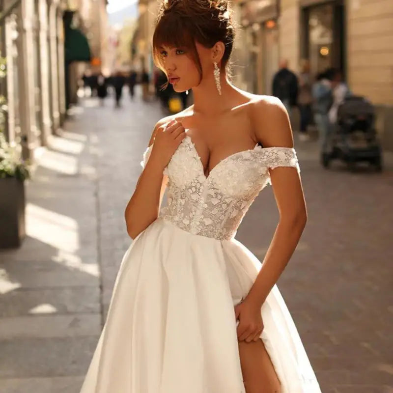 Introducing Dress Eleanor, the ultimate bohemian V-neck wedding dress. With its off the shoulder design, high side slit, and backless style, this dress exudes sexy sophistication. The intricate lace applique and A-line silhouette add a touch of femininity to complete the look. Perfect for the free-spirited bride looking to make a statement on her special day.