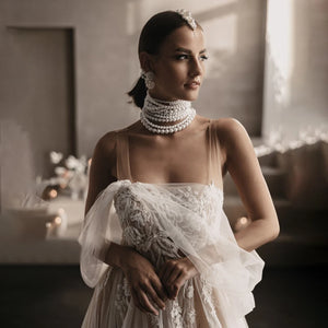 Elevate your wedding day with the Robe Satine, designed with seduction in mind. The off shoulder, high split design is delicately adorned with tulle appliques, shirred sleeves, and intricate beading lace. Its silhouette is perfect for maternity photoshoots and will make you feel like a goddess on your special day.