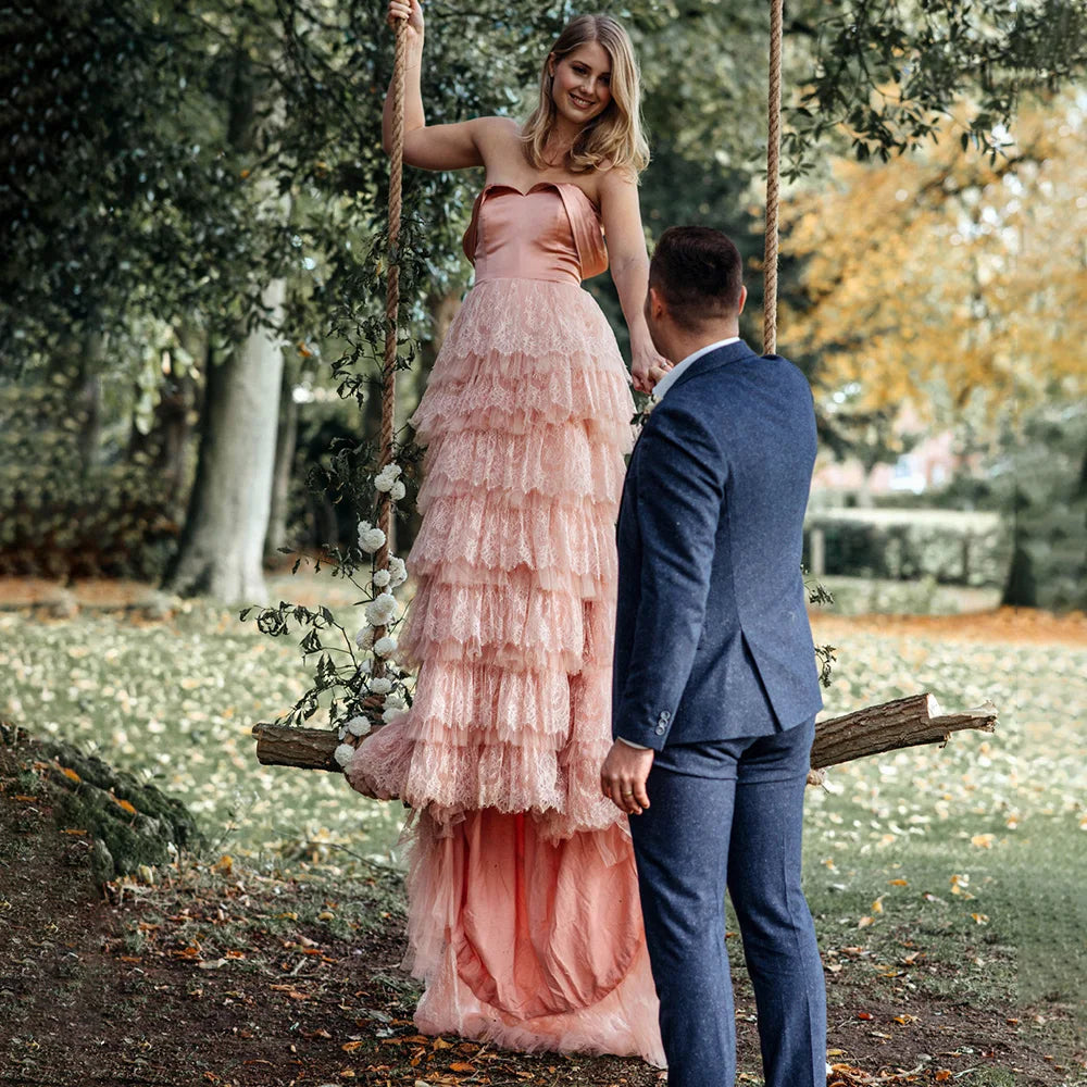 Elevate your wedding day in the exquisite off shoulder Robe Melissa. Crafted with delicate tiered lace in a dreamy mauve pink hue, this A-line custom-made gown is perfect for the plus-size bride. With a breathtaking long train and tutu details, this dress is a must-have for your elopement photoshoot.