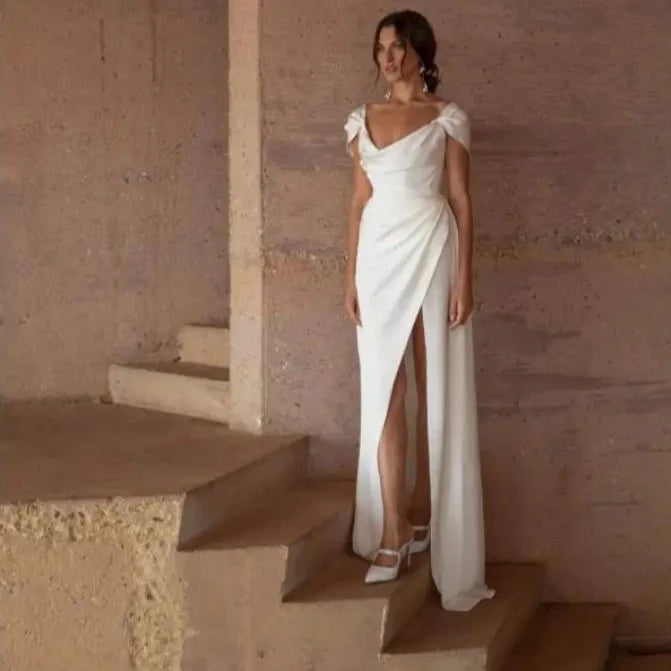 Expertly crafted for the modern bride, the Robe Rosemarie is a stunning blend of simplicity and elegance. With a figure-flattering A-line silhouette and a delicate off-the-shoulder neckline, this chiffon wedding dress exudes effortless beauty. The sexy side split and V-back add a touch of sensuality, making it the perfect choice for a beach wedding. Available in a charming rose color, this dress will make any bride feel like a vision on her special day.