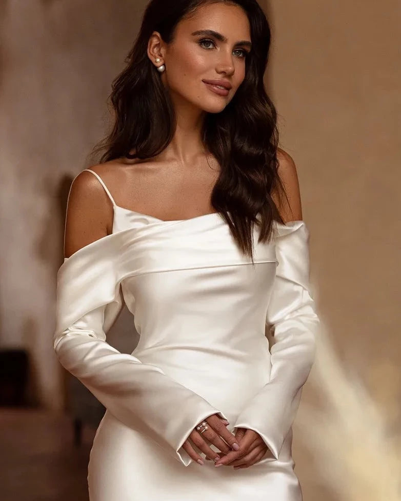 Indulge in luxury with Dress Jules - an elegant, custom-made bridal gown featuring long sleeves and a court train. This trumpet style dress is the epitome of simplicity and sophistication, perfect for a timeless and tasteful wedding. Elevate your special day with Dress Jules.