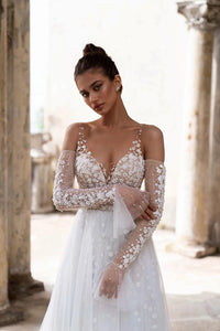 Unleash your inner boho goddess with our Robe Linnet! This stunning V-neck wedding gown features delicate dotted tulle, detachable sleeves, and ruched details for a dreamy, ethereal look. Perfect for the free-spirited bride who loves a touch of whimsy on her special day. Say 'I do' to the Robe Linnet!