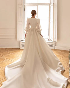 Feel like a princess on your special day with our Robe Sancia. The square neckline and full, long sleeve puff design adds elegance to the A-line silhouette. This two-piece bridal gown is perfect for any bride, ensuring a stunning and timeless look