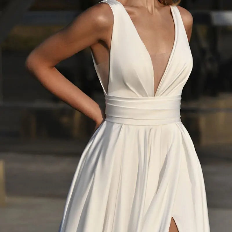 Get ready to stun in the Robe Zenna! This elegant wedding dress features a deep V-neck and backless design, perfect for those who want to make a statement. The spaghetti straps add a touch of delicacy, while the side slit and A-line cut flatter your figure. Feel like a goddess on your special day.
