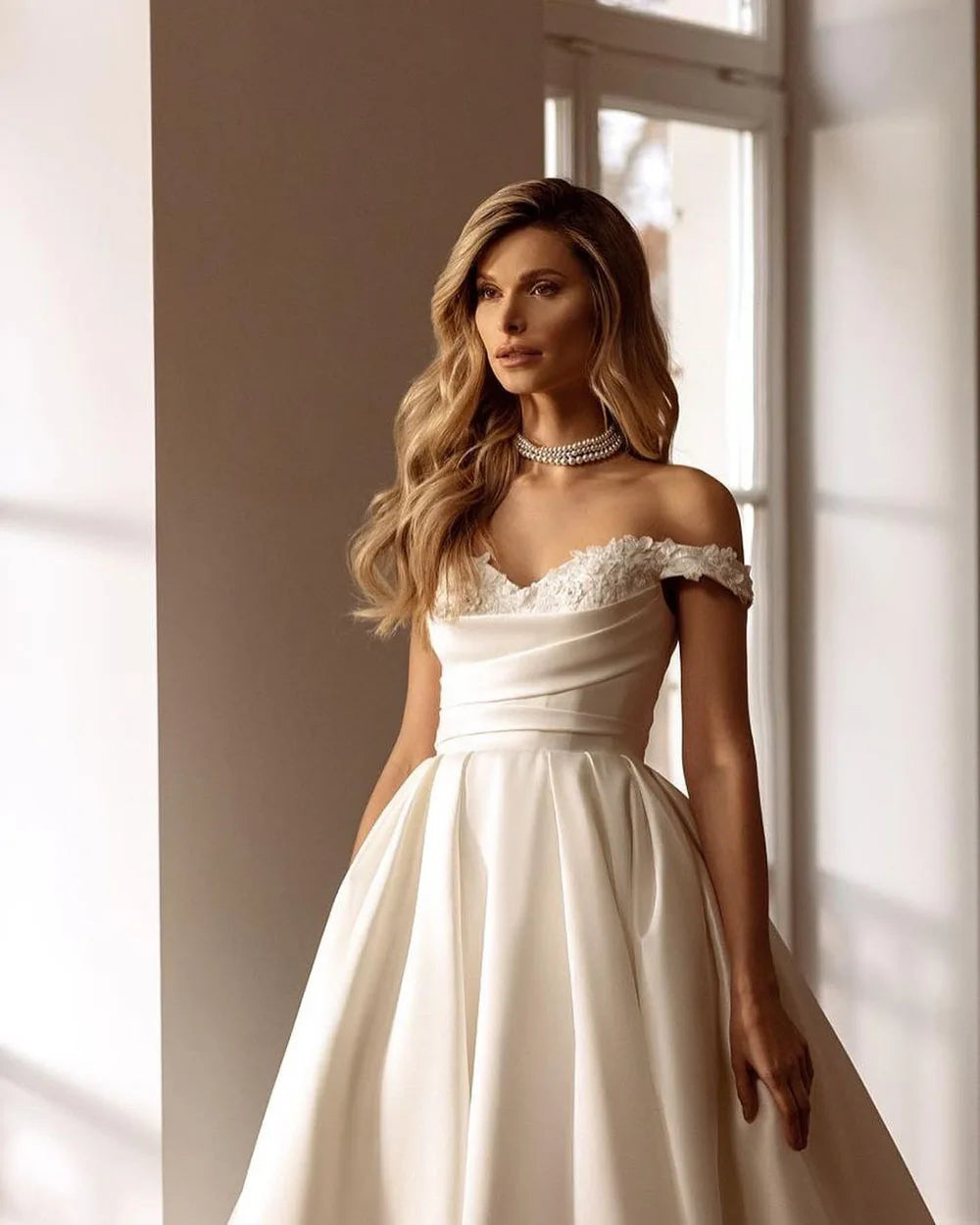 Indulge in luxury and sophistication with the vintage satin Robe Laverne. This off-shoulder A-line gown is crafted to perfection, featuring a backless design that will make you stand out on your special day. Be the epitome of elegance and grace with this timeless and romantic bridal gown.
