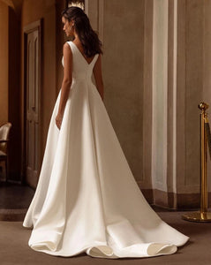 Indulge in the opulent elegance of the Robe Loire. Made with sumptuous satin and featuring a pleated sleeveless design, this V neck bridal dress is perfect for a beach wedding. Its luxurious fabric and sophisticated silhouette will make you feel like the belle of the ball on your special day.