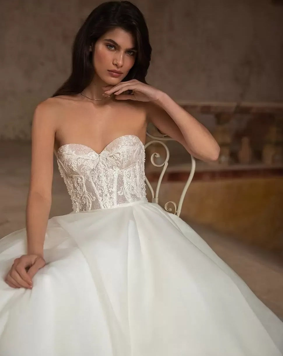 Unleash your playful and elegant side with Robe Eva! This A-line bridal gown features stunning appliques, perfect for your big day. Make a statement with this tres elegante robe, designed for the fashion-forward bride. Say oui to style!