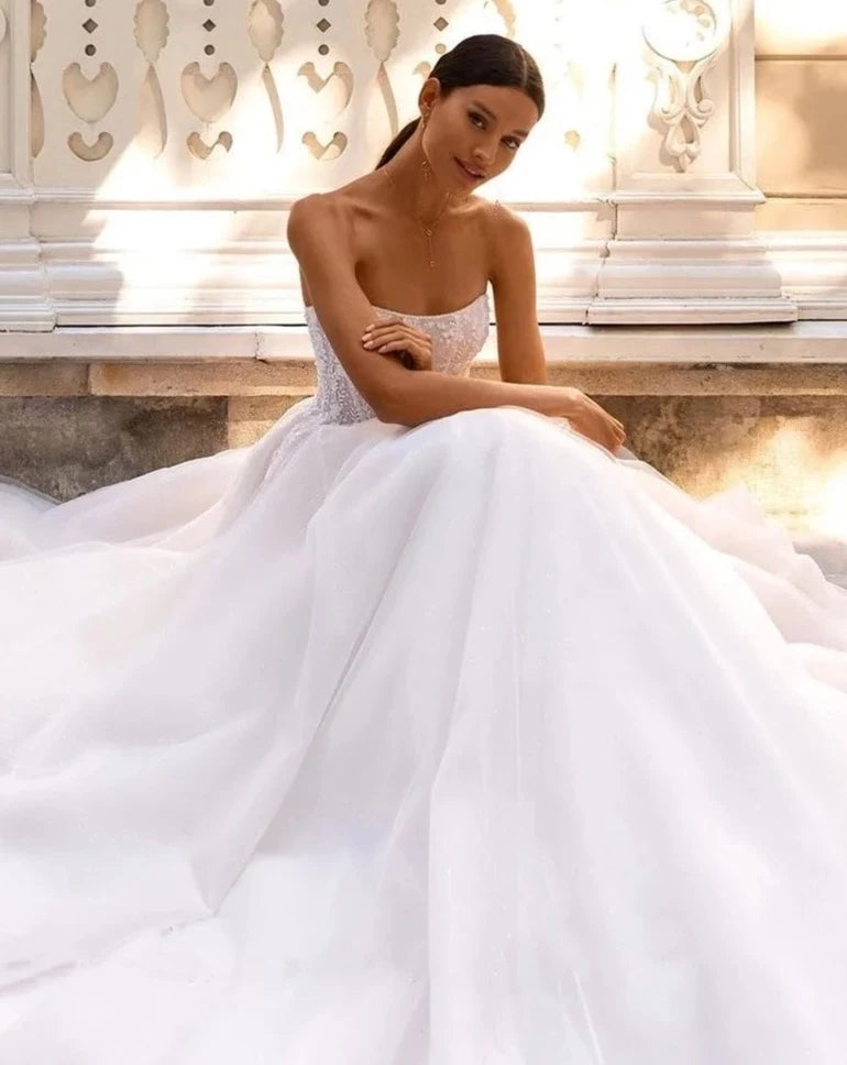 Indulge in pure luxury with the Robe Amia. This elegant off the shoulder A-line wedding dress boasts a sleeveless design that exudes sophistication. Adorned with vintage sequin lace applique and delicate tulle, this bridal gown is a work of art. Make a statement on your special day with the Robe Amia.
