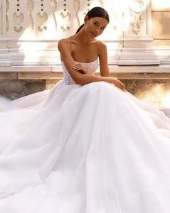 Indulge in pure luxury with the Robe Amia. This elegant off the shoulder A-line wedding dress boasts a sleeveless design that exudes sophistication. Adorned with vintage sequin lace applique and delicate tulle, this bridal gown is a work of art. Make a statement on your special day with the Robe Amia.