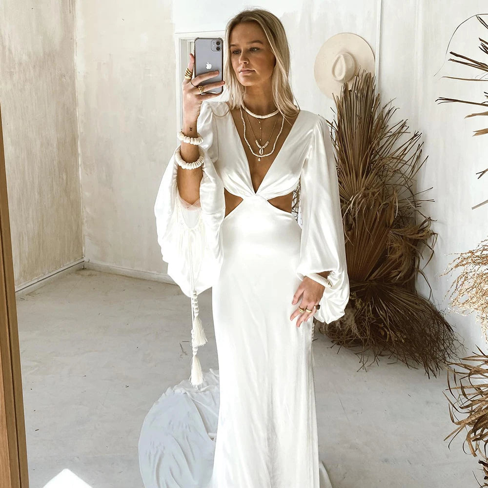 Indulge in the luxurious elegance of the Robe Suzanne. Featuring long bishop sleeves, an open back, and a side cutout, this custom-made wedding gown is made of flowing chiffon, accentuating every curve. With a sexy V-neck design, this dress is perfect for the modern bride looking for a simple yet stunning look.