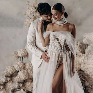 Elevate your wedding day with the Robe Satine, designed with seduction in mind. The off shoulder, high split design is delicately adorned with tulle appliques, shirred sleeves, and intricate beading lace. Its silhouette is perfect for maternity photoshoots and will make you feel like a goddess on your special day.