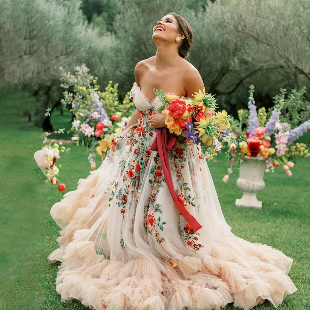 Treat your special day with the Robe Lucianna - a dreamy wedding dress with fairy colorful embroidery, a puffy mesh tulle overlay, and a sweetheart neckline. Feel like a bloomin' flower in this delicate champagne gown! No doubt, you'll be making a stunning statement on your big day.