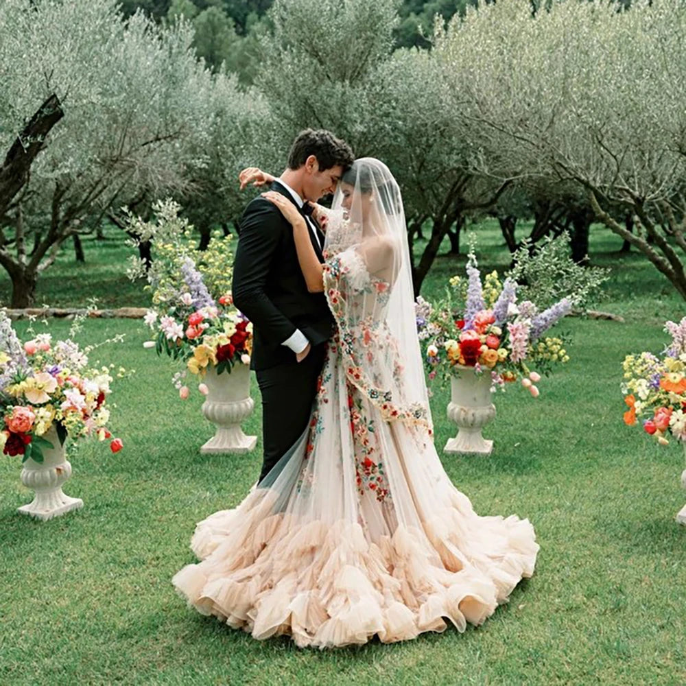 Treat your special day with the Robe Lucianna - a dreamy wedding dress with fairy colorful embroidery, a puffy mesh tulle overlay, and a sweetheart neckline. Feel like a bloomin' flower in this delicate champagne gown! No doubt, you'll be making a stunning statement on your big day.