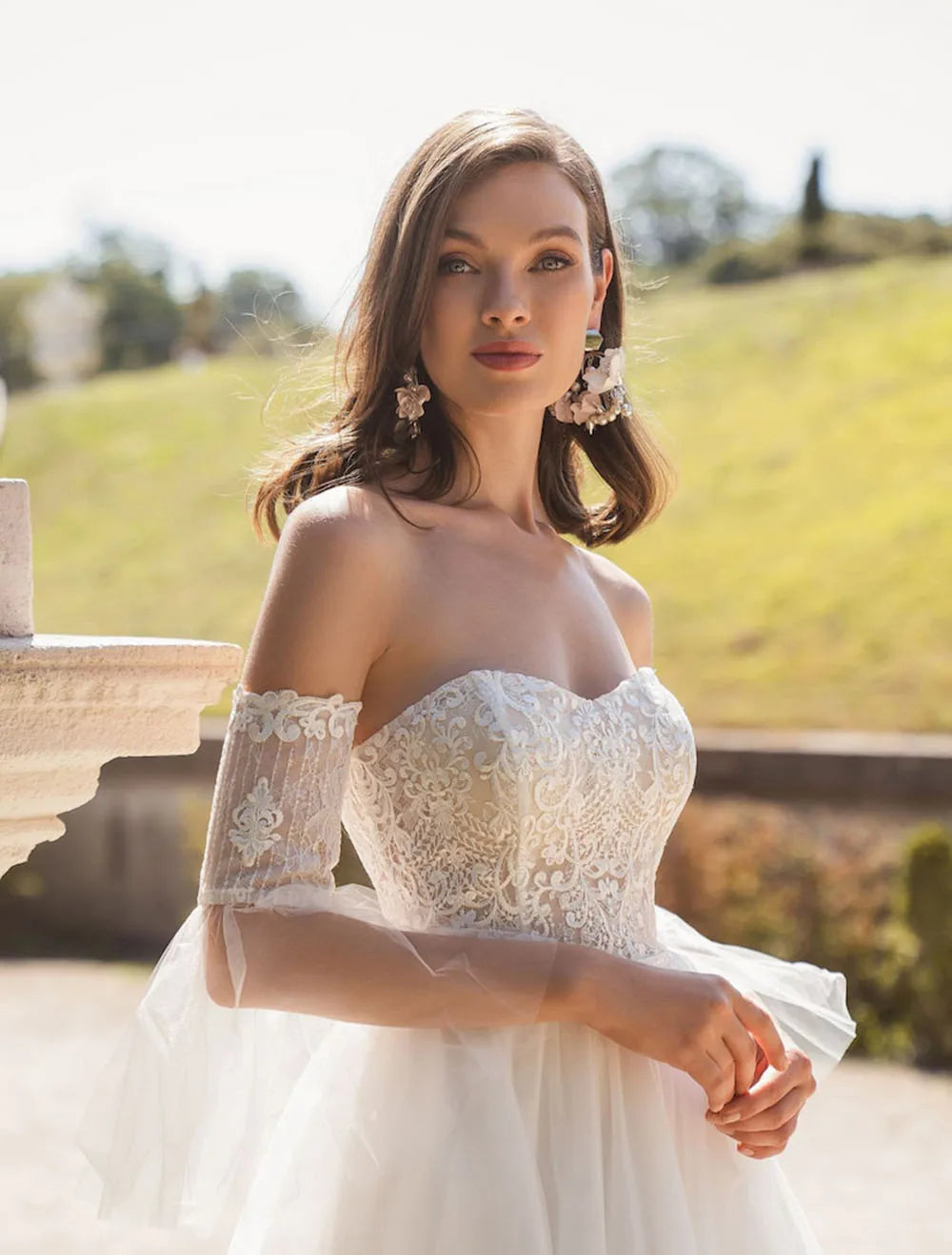 Look stunning on your special day with the Robe Danique. The off the shoulder design and delicate lace appliques give this dress a romantic, boho feel. The tulle sweep train adds a touch of elegance, making it perfect for a civil wedding. Say "I do" in style with this beautiful bridal dress.