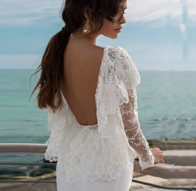 Expertly designed for your special day, the Robe Chelsea is an elegant mermaid-style wedding dress. With long sleeves, a stunning backless design, and a lace and tulle construction, this dress exudes timeless elegance. Complete with a side slit and a sweeping train, it is the perfect blend of modern and traditional.