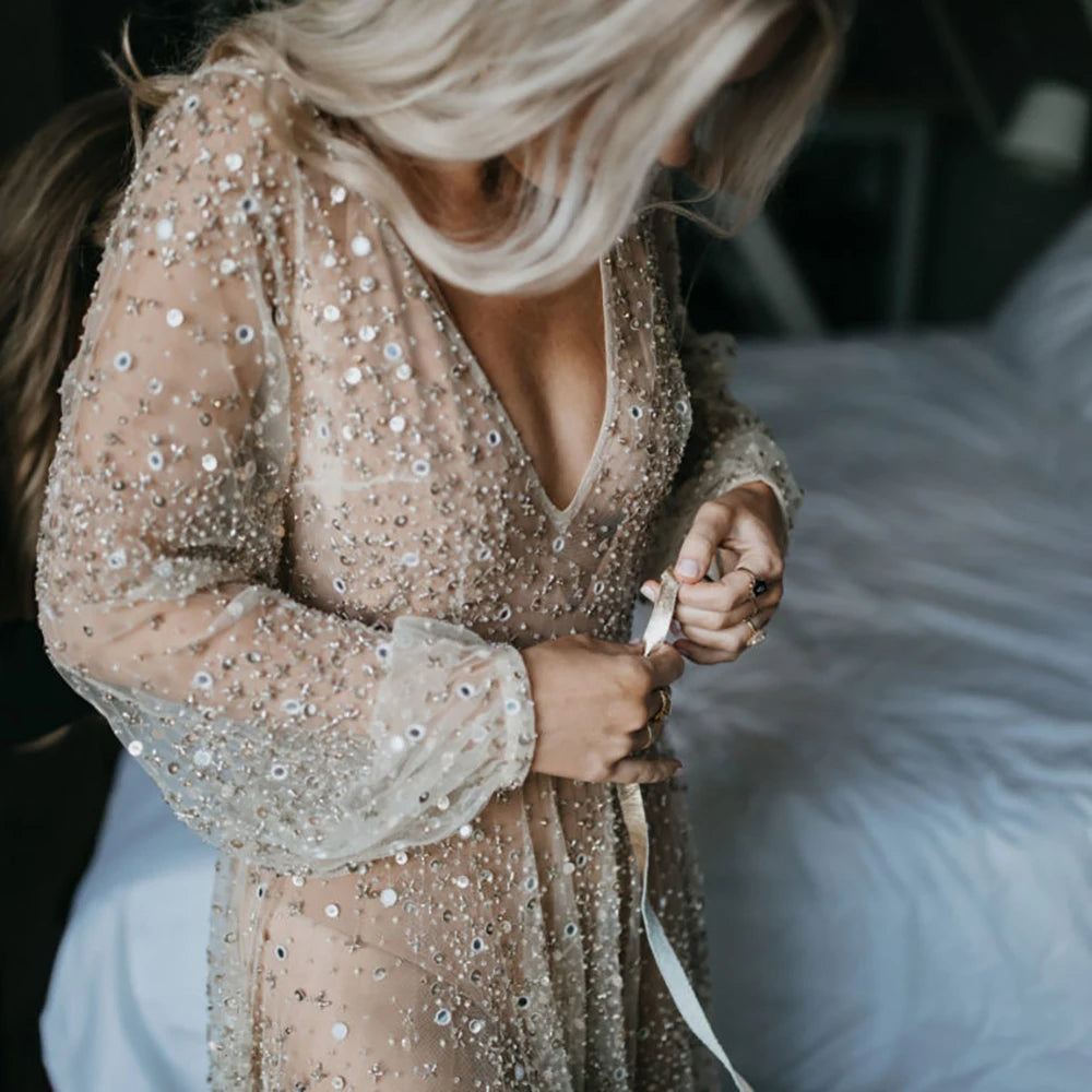 Indulge in the opulence of our Dress Carrie. This luxurious A-line gown boasts intricate beading, a see-through V-neckline, and a backless design. Adorned with sparkling Swarovski crystals and flowing layers of illusion tulle, it's a custom-made masterpiece fit for a bride's most special day.