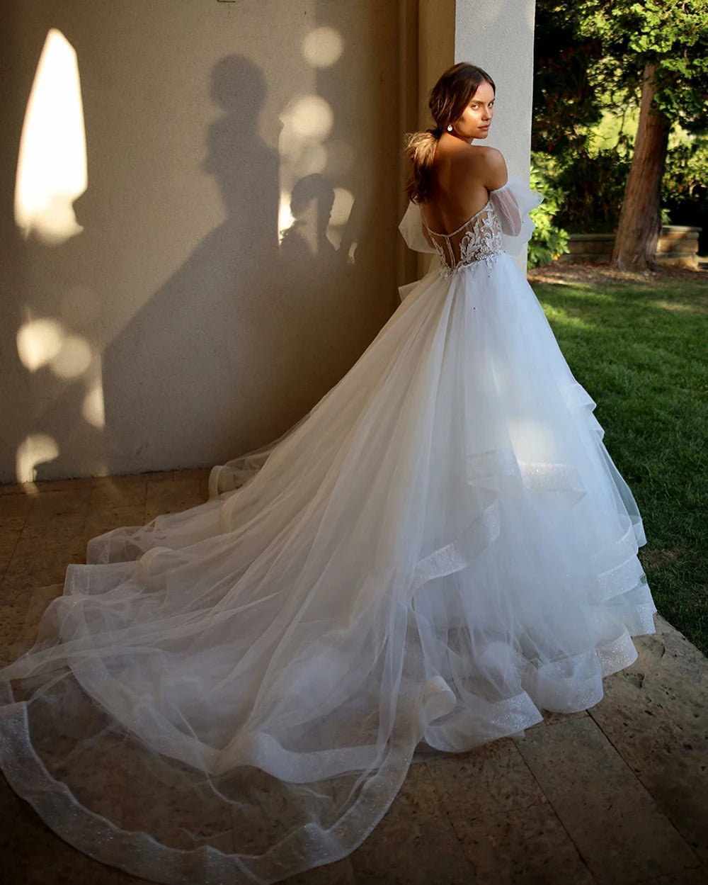 Elevate your wedding day style with the Robe Aurélie. Exquisite lace and tulle create a princess-worthy ball gown that will make you feel like royalty on your special day. The sweetheart neckline and puffed sleeves add a touch of boho charm, making this dress a dreamy choice for any bride.