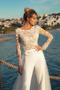 Experience the feminine grace of the Combinaison Nadine exquisite wedding gown. Embellished with opulent appliques and a detachable train, this elegant jumpsuit will make you the center of attention. Enjoy the timeless glamour of luxury fashion on your special day.