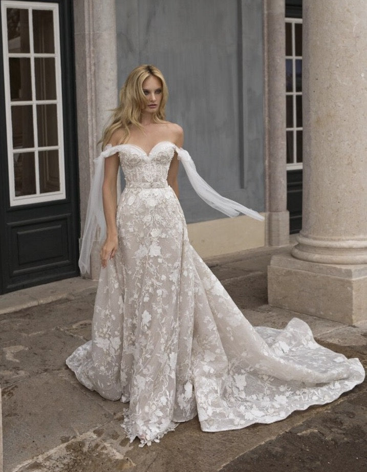 Make your wedding day extra special in our one-of-a-kind Robe Beau! This off-the-shoulder lace beauty will have you feeling like a princess, with its appliqué details, fit for a queen! Lace up your wedding day look with the Robe Beau and make it a moment you'll never forget!