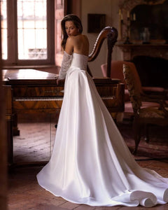 Elevate your bridal look with our Robe Noémie. Crafted with shimmering sequins and delicate beading, this satin dress exudes sophistication. The detachable train offers versatility, while the off the shoulder design adds a touch of romance. Perfect for the modern bride looking for a statement dress.