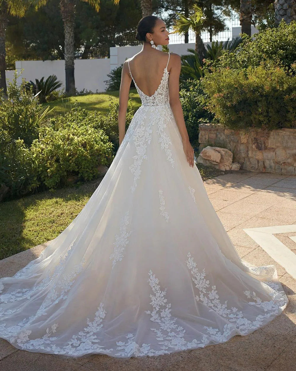 Crafted with exquisite detail, the Robe Zenna adds a touch of romantic elegance to any wedding. The delicate lace flowers and princess tulle create a stunning A-line silhouette, while the V-neckline and appliques accentuate the bride's natural beauty. Perfect for the boho-inspired bride, this dress is a must-have for any wedding day.