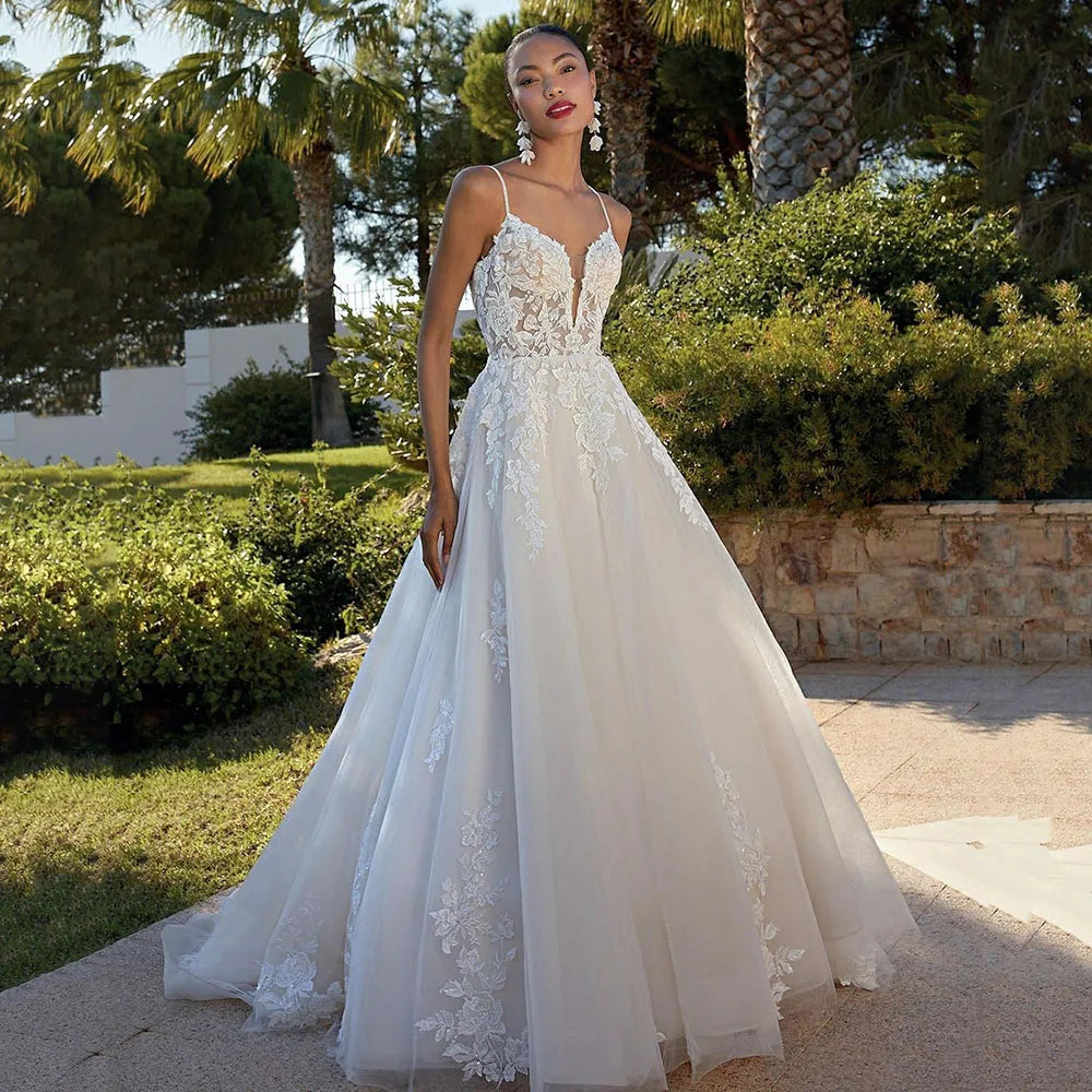Crafted with exquisite detail, the Robe Zenna adds a touch of romantic elegance to any wedding. The delicate lace flowers and princess tulle create a stunning A-line silhouette, while the V-neckline and appliques accentuate the bride's natural beauty. Perfect for the boho-inspired bride, this dress is a must-have for any wedding day.