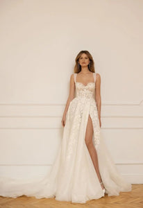 Wrap yourself in luxury with our elegant Robe Remi. The A-line silhouette and spaghetti straps gown give off a chic vibe, while the open leg adds a touch of fantasy. Made with exquisite craftsmanship, this gown is perfect for your dream wedding.