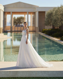 Feel like a modern princess in our Dress Jossette! With a square neck, delicate spaghetti straps, and a stunning open back, this ivory wedding dress is sure to turn heads. Made with high-quality tulle, this custom piece is perfect for your special day. And with a sweeping train, you'll feel like royalty as you walk down the aisle. Order now and make your dream wedding a reality!