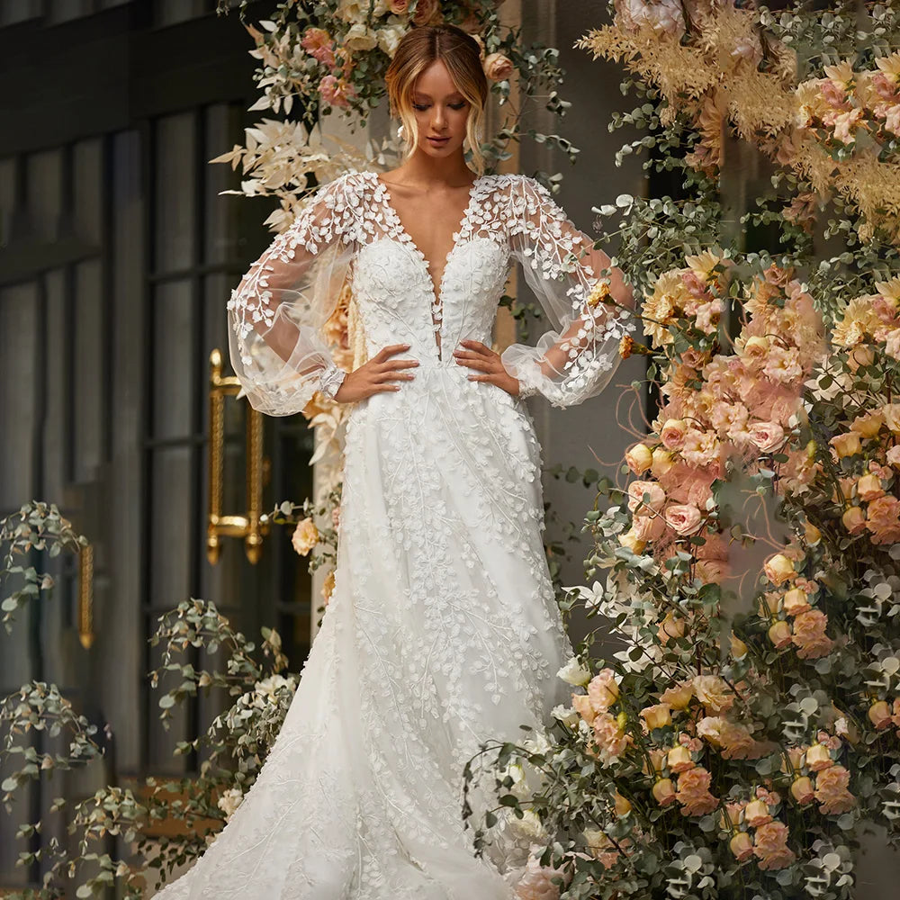 Robe Marian is an exquisite masterpiece, crafted from luxurious mesh tulle with delicate embroidery. The intricate details of the 3D lace and open back create a timeless silhouette, while the long puffy sleeves, low V neckline and custom fit bring out the best of your figure. Perfect for the most special occasions, this gown will make you look and feel truly radiant.
