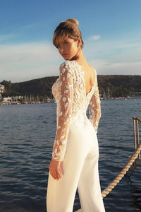 Experience the feminine grace of the Combinaison Nadine exquisite wedding gown. Embellished with opulent appliques and a detachable train, this elegant jumpsuit will make you the center of attention. Enjoy the timeless glamour of luxury fashion on your special day.