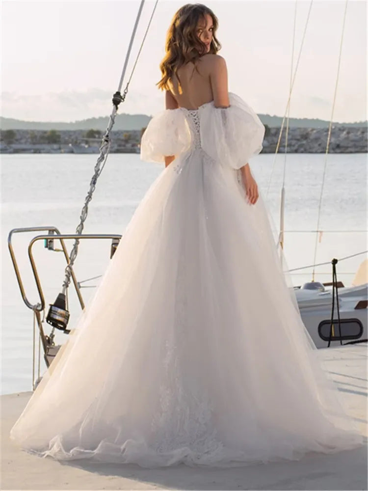 Elevate your special day with our Robe Rene, a luxurious lace ball gown that exudes elegance and sophistication. The off-shoulder design adds a touch of romance, making you feel like a modern-day princess. Perfect for a wedding or any lavish event. Experience the ultimate in style and grace with our Robe Rene.