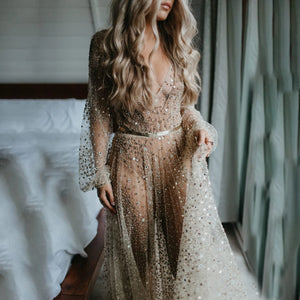 Indulge in the opulence of our Dress Carrie. This luxurious A-line gown boasts intricate beading, a see-through V-neckline, and a backless design. Adorned with sparkling Swarovski crystals and flowing layers of illusion tulle, it's a custom-made masterpiece fit for a bride's most special day.