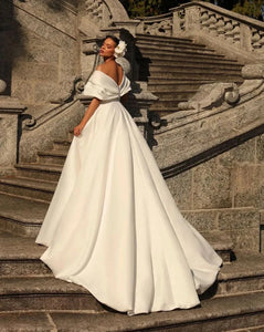Feel like a true princess on your special day with the Robe Petrusia! The elegant A-Line silhouette, delicate cap sleeves, and intricate pleating create a timeless look that will make you feel confident and beautiful. Perfect for any bride looking for a classic and sophisticated wedding dress.