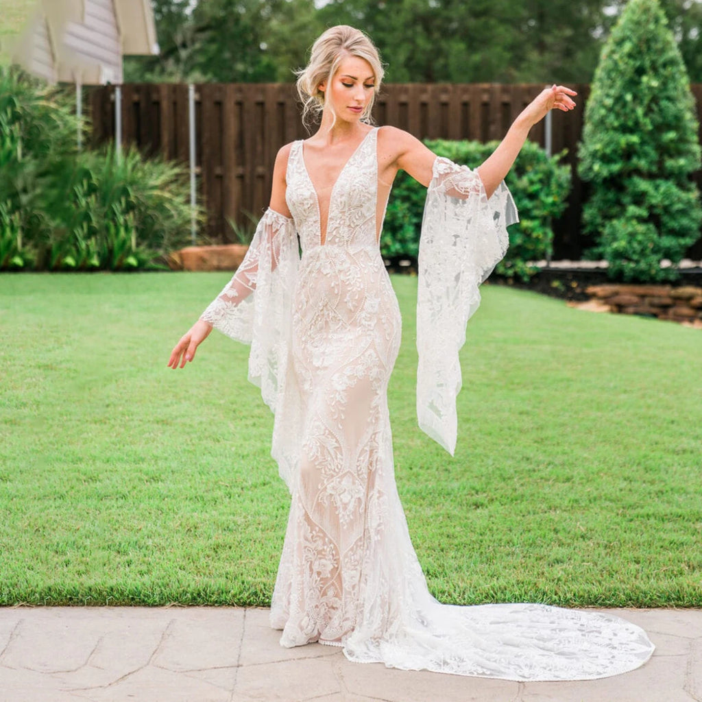 Unleash your inner mermaid with Dress Marina! Its long elastic batwing sleeves and elegant mermaid silhouette make it the ideal lace wedding dress for beachside nuptials. And let's not overlook the dazzling sequin accents - you'll radiate like the night sky in this captivating gown.