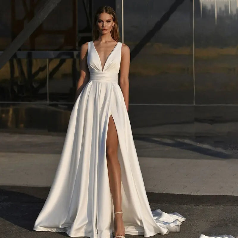 Get ready to stun in the Robe Zenna! This elegant wedding dress features a deep V-neck and backless design, perfect for those who want to make a statement. The spaghetti straps add a touch of delicacy, while the side slit and A-line cut flatter your figure. Feel like a goddess on your special day.
