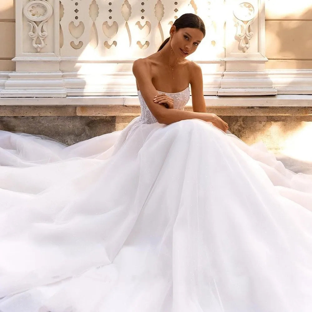 This dress captures the essence of bohemian style with its off-the-shoulder design and intricate lace appliques. Perfect for a vintage-inspired wedding, it features a timeless ball gown silhouette and shimmering sequin accents. Feel confident and radiant on your special day with Dress Camille!