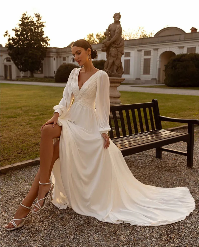 Embrace your inner bohemian goddess with Dress Michelle. The flowy chiffon and long sleeves create a dreamy A-line silhouette, perfect for a custom-made wedding dress. Add a touch of whimsy with the sweep train, making you feel like a true boho bride. Let your free-spirited style shine on your special day.