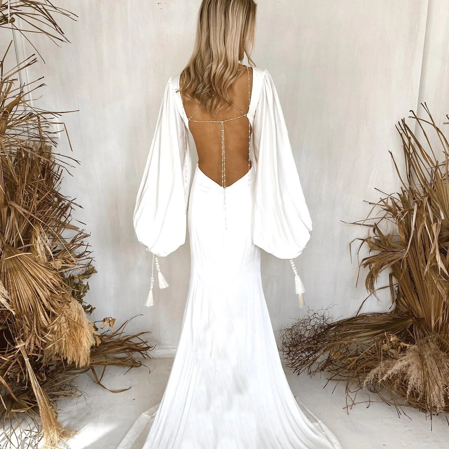 Indulge in the luxurious elegance of the Robe Suzanne. Featuring long bishop sleeves, an open back, and a side cutout, this custom-made wedding gown is made of flowing chiffon, accentuating every curve. With a sexy V-neck design, this dress is perfect for the modern bride looking for a simple yet stunning look.