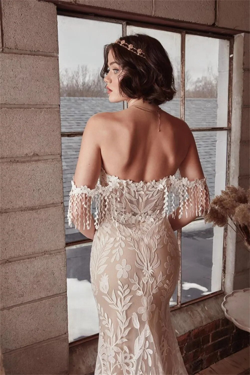 This Robe Cosette wedding dress is the perfect mix of sweet and sexy. The sheath silhouette and delicate lace fabric are complemented by an off-the-shoulder neckline and sweep train. Highly flattering and comfortable, this bridal gown is perfect for a church or civil wedding.