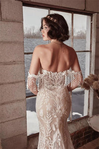 This Robe Cosette wedding dress is the perfect mix of sweet and sexy. The sheath silhouette and delicate lace fabric are complemented by an off-the-shoulder neckline and sweep train. Highly flattering and comfortable, this bridal gown is perfect for a church or civil wedding.