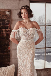 This Robe Cosette wedding dress is the perfect mix of sweet and sexy. The sheath silhouette and delicate lace fabric are complemented by an off-the-shoulder neckline and sweep train. Highly flattering and comfortable, this bridal gown is perfect for a church or civil wedding.