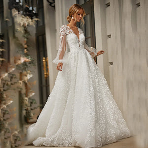 Robe Marian is an exquisite masterpiece, crafted from luxurious mesh tulle with delicate embroidery. The intricate details of the 3D lace and open back create a timeless silhouette, while the long puffy sleeves, low V neckline and custom fit bring out the best of your figure. Perfect for the most special occasions, this gown will make you look and feel truly radiant.