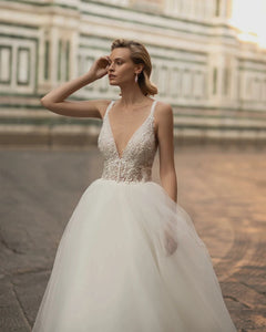 Indulge in pure elegance with the Robe Emeraude. This wedding dress features a seductive V-neck, delicate lace and luxurious tulle fabric, and a stunning backless design fit for a princess. Perfect for the sophisticated bride who wants to make a statement on her special day.